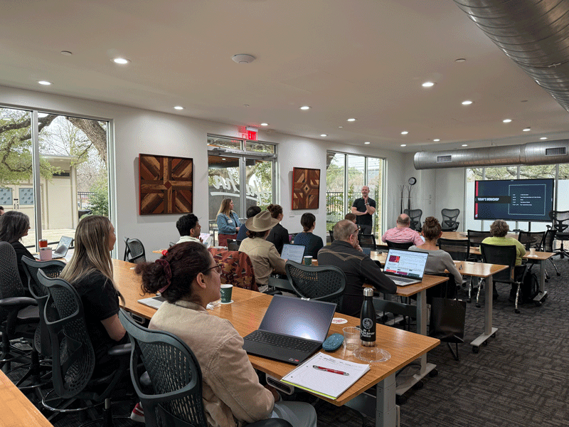 Attendees at Austin LGBT Chamber of Commerce event in a modern conference room.